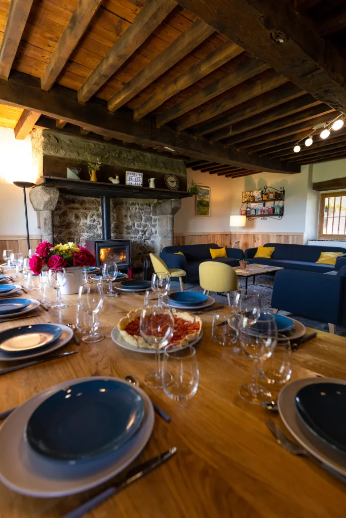 Grande table dressée avec vaisselle bleue sous les poutres