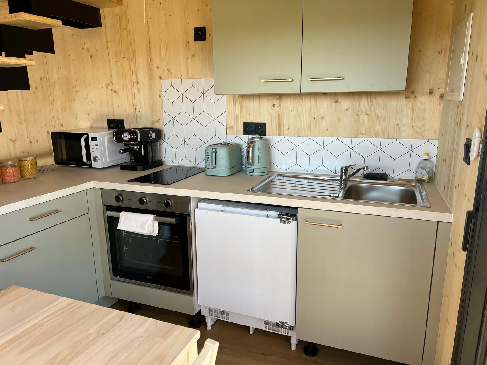 Cuisine équipée du COQhome, ambiance bois et vert d'eau