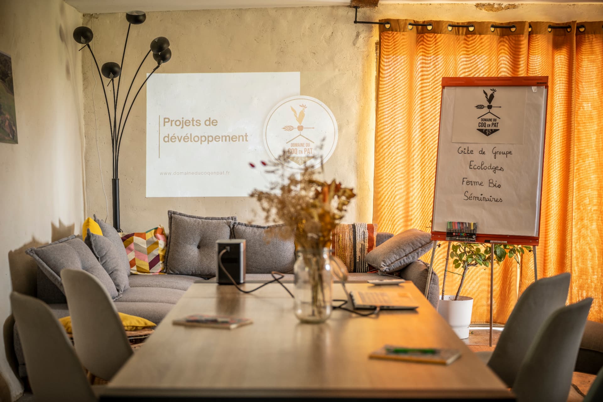 Salle de réunion du gîte préparée pour un séminaire, paperboard et vidéoprojection